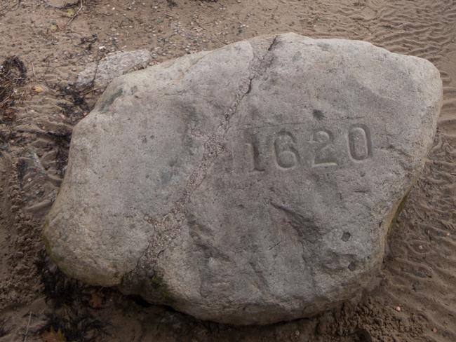 Plymouth Rock sits on the beach in Plymouth Ma, inside it's caged enclosure.