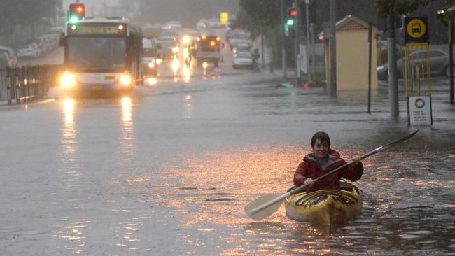 A woman paddles her kayak along Pittwater Road in Narrabeen yesterday. Picture: Jeremy Piper