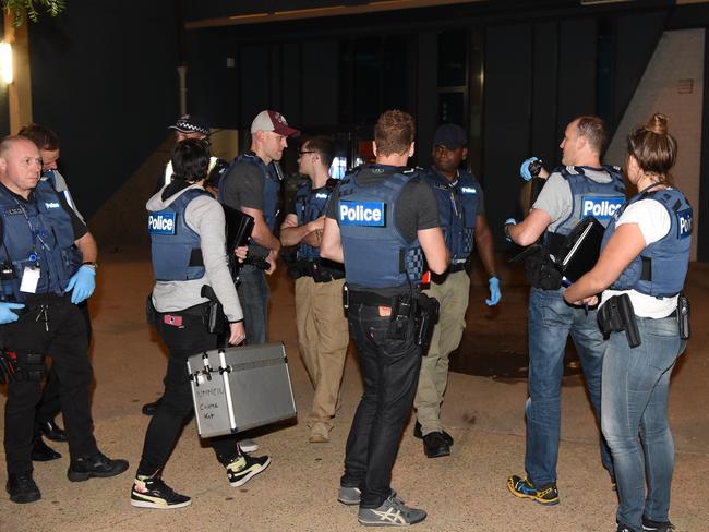 Detectives prepare to enter flats in Carlton. Picture: Tony Gough