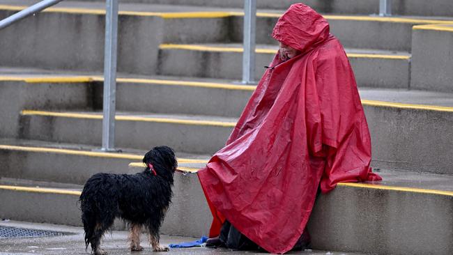 VAFA: A spectator tries to keep dry during the Old Trinity and Old Xaverians match. Picture: Andy Brownbill