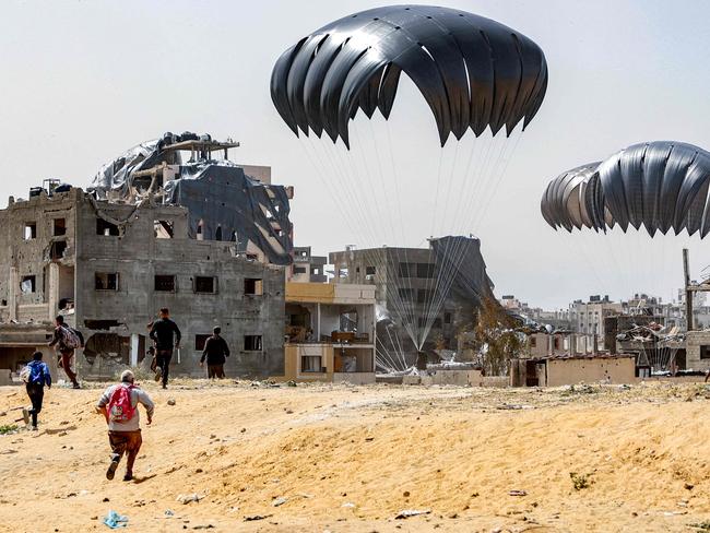 People rush to landing humanitarian aid packages dropped over the northern Gaza Strip. Picture: AFP