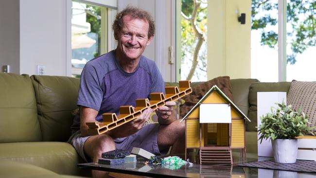 Former surfboard designer Nev Hyman, founder of Nevhouse at his Robina home with an example of the recycled plastic material that can be made into low-cost housing. Picture: NIGEL HALLETT