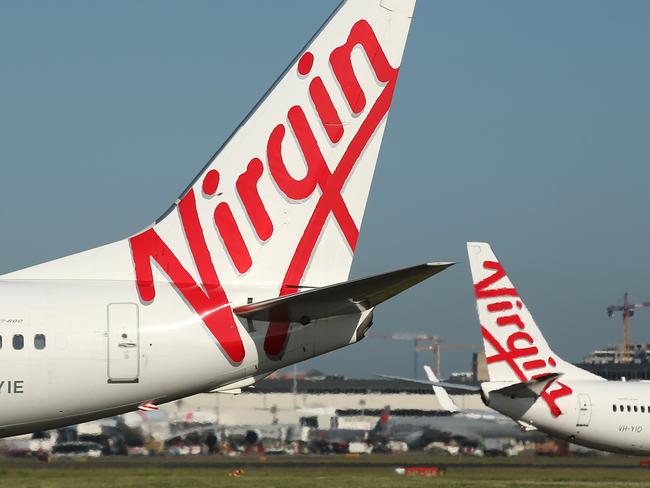 The Virgin Australia Holdings Ltd. logo is displayed on the tails of a Boeing Co. 737-800, left, and a Boeing Co. 737-8FE aircraft preparing to take off at Sydney Airport in Sydney, Australia, on Monday, Feb. 8, 2016. Virgin Australia is scheduled to announce half-year earnings on Feb. 11. Photographer: Brendon Thorne/Bloomberg