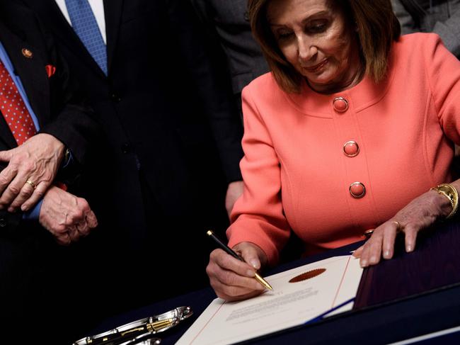 Democrat Speaker of the House Nancy Pelosi signs the articles of impeachment. Picture: AFP