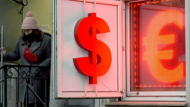 A woman leaves a currency exchange office displaying the US dollar and the euro signs in Saint Petersburg on March, 2, 2022. Picture: AFP