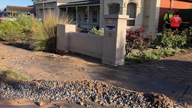 Emergency workers examine the damage caused to homes along Broughton Ave, Mitcham after a water main burst on Fullarton Rd. Picture: Keryn Stevens