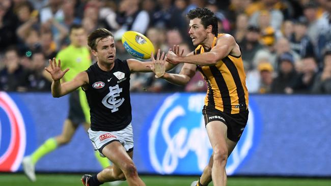 Isaac Smith gets a handball away in front of Carlton’s Lochie O'Brien. Picture: AAP