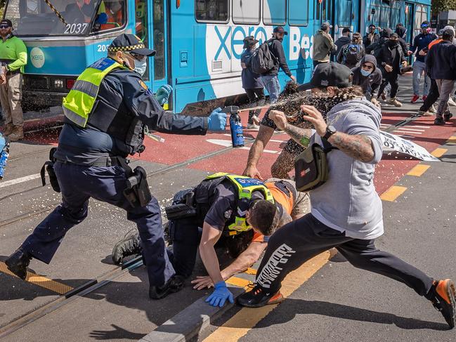 A police officer rushes to help his colleague in a fracas. Picture: Jason Edwards