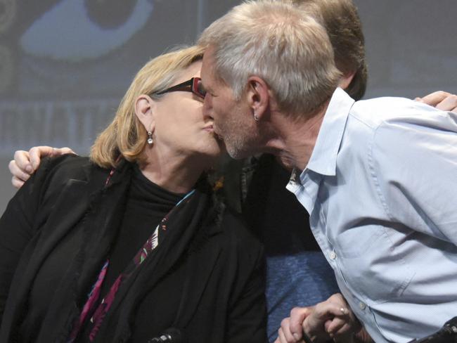 Carrie Fisher, left, and Harrison Ford kiss at Comic-Con in 2015. Picture: Richard Shotwell/Invision/AP, File