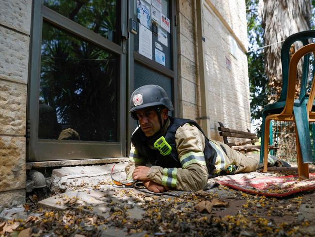 An Israeli firefighter takes cover as sirens sound to warn of rockets launched from southern Lebanon, in Kiryat Shmona in northern Israel near the Lebanese border on June 19, 2024. Picture: AFP