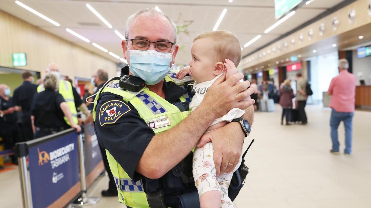 Tasmania Police Senior Constable Paul Edwards who was working at the airport on day 1 of border reopening reunited with granddaughter Isla 7 months from Newcastle who have been separated since she was 4 weeks old. Picture: Nikki Davis-Jones