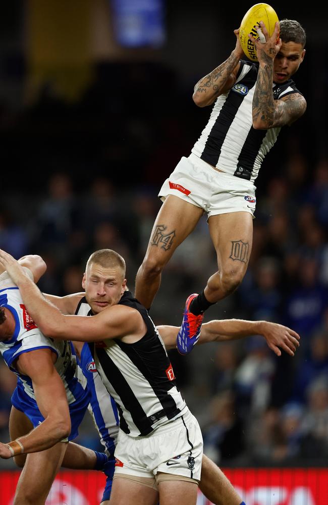 Bobby Hill of the Magpies takes a spectacular mark over Billy Frampton and Charlie Comben on Sunday. Picture: Michael Willson/AFL Photos via Getty Images.