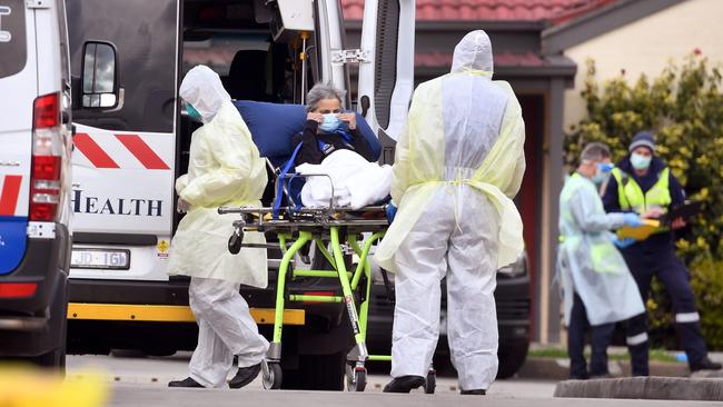 Ambulance officers remove a resident from the St Basil's Home