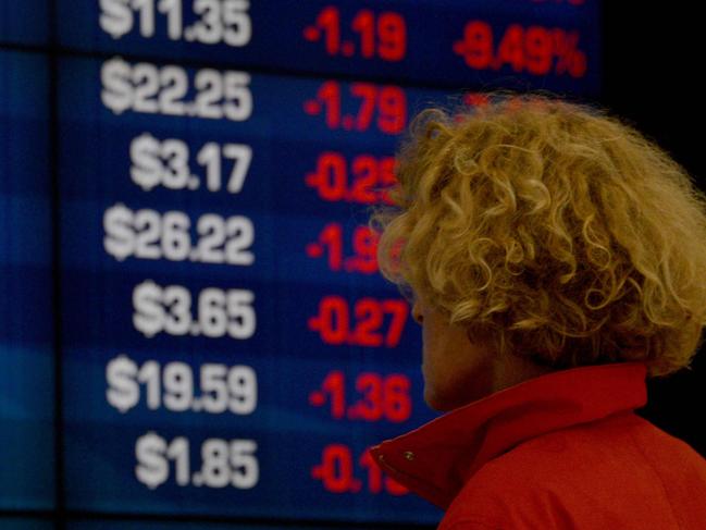 A visitor to the Australian Securities Exchange (ASX) looks at share prices on a big screen in Sydney on October 11, 2018. - The Australian share market joined the regional bloodbath after the sell off on Wall Street, plunging to a more than five-month low as all sectors dropped into the red. (Photo by PETER PARKS / AFP)