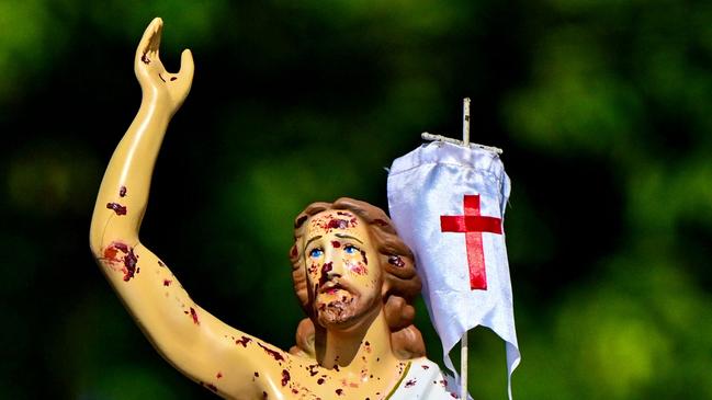 Christian devotees carry a partly damaged statue of Jesus salvaged from rubble after the 2019 Easter Sunday bombing, during an Easter procession to mark the fifth anniversary of the attack, at St. Sebastian's Church in Katuwapitiya on March 31, 2024. (Photo by Ishara S. KODIKARA / AFP)