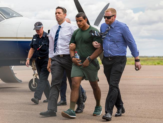 Jermaine Austral is escorted by police upon his return to Alice Springs. Photo: EMMA MURRAY