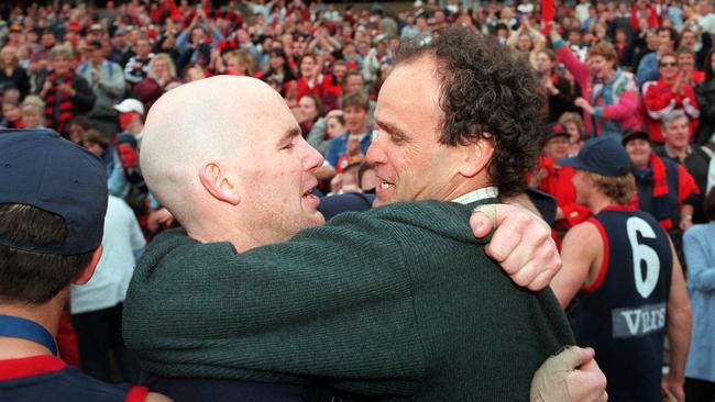 Michael Aish celebrates the 1997 SANFL premiership with Norwood player Andrew Jarman.