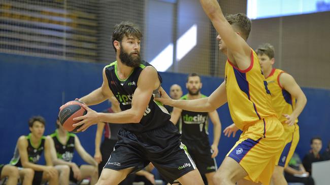 USC Rip City player, Josh Tueta, looks for support against Brisbane Capitals in a basketball match at the USC Sports Stadium.