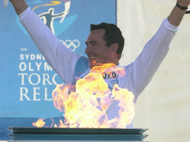 Olympic Torch Relay Day 89, Penrith to Bowral. Torchbearer Pat Farmer carrying flame and lighting cauldron on 04 Sep 2000.