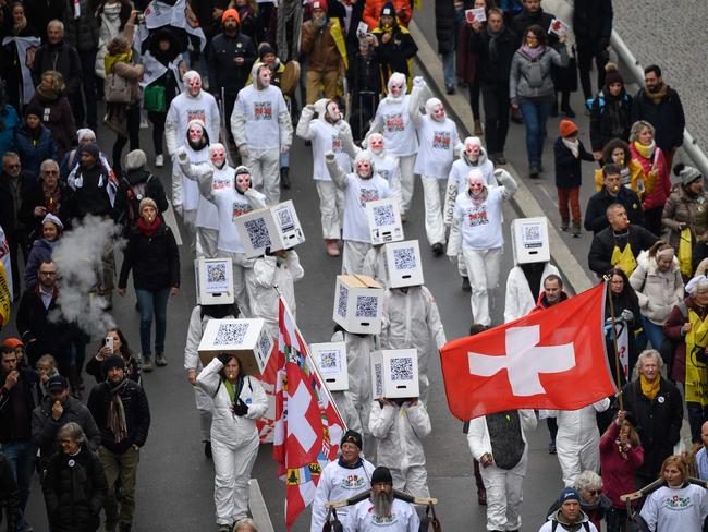 Protesters hold flags and banners during a protest against the current measures to tackle the spread of Covid-19 health pass and vaccination, in Lausanne Switzerland. Picture: AFP