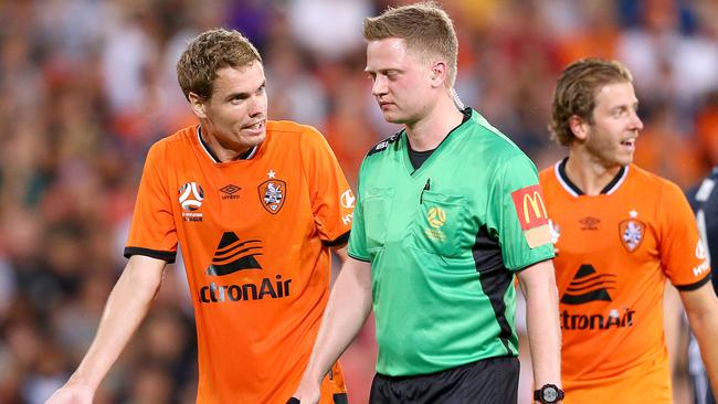 Thomas Kristensen of the Roar argues with referee Adam Fielding who has the Respect logo on his left sleeve covered with tape. Picture: AAP