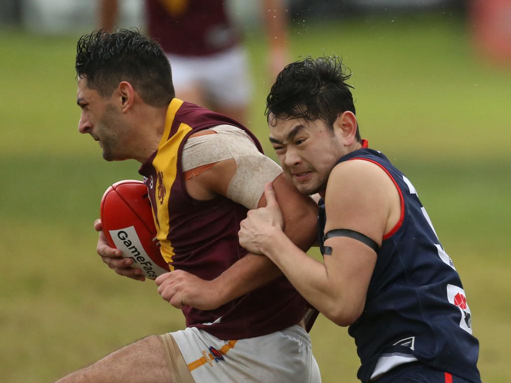 Murrumbeena’s David Schmiedl can’t escape a tackle in the wet. Picture: Stuart Milligan