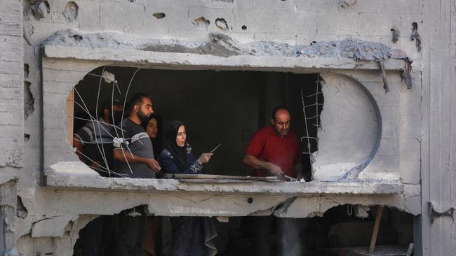 Palestinians clear the rubble from a damaged apartment block following overnight Israeli strikes in al-Bureij refugee camp. Picture: AFP