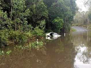 ROAD CLOSED: A car tried to cross the flooded Farnsfield Rd near Childers overnight. Picture: Contributed