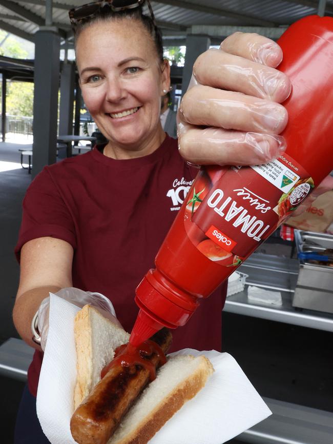 Snag, bread, squirt of sauce: Alisha Gordon serves up Democracy Sausage on voting day at Brisbane State High School in 2022. Picture: Liam Kidston