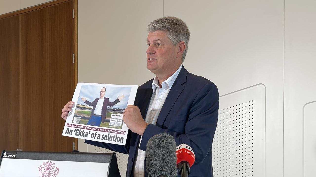 Sports Minister Stirling Hinchliffe parading a previous newspaper clipping from The Courier-Mail in which Lord Mayor Adrian Schrinner backs a stadium at the RNA showgrounds.