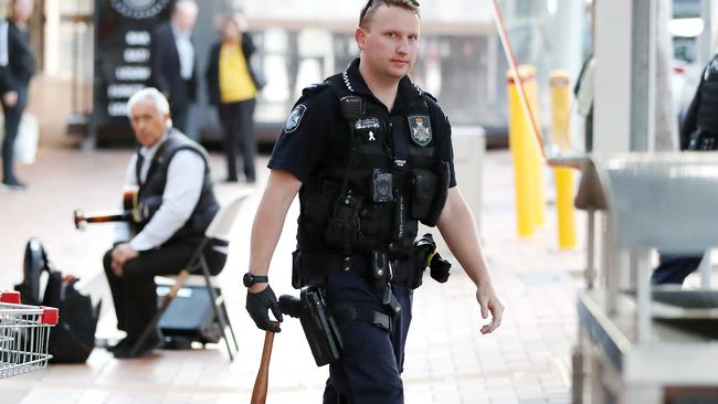 A policeman carries a wooden club used during the dispute. Picture: Nigel Hallett