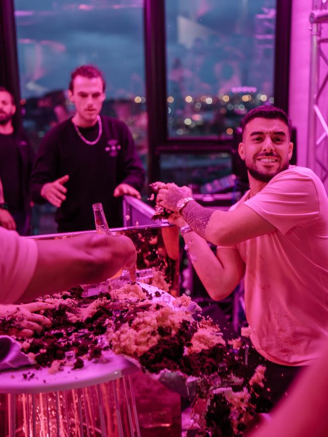 Portelli throwing handfuls of a giant cake onto guests. Picture: Supplied