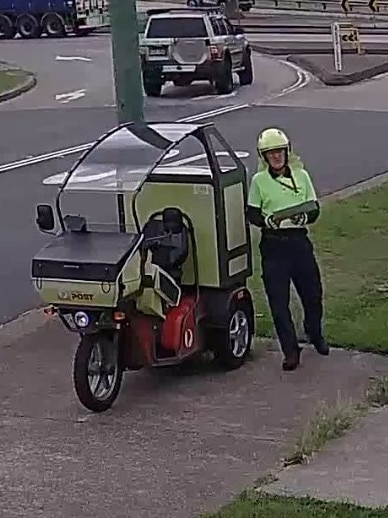 The postie retrieves the post from the back of their bike before sitting back down. Picture: Facebook