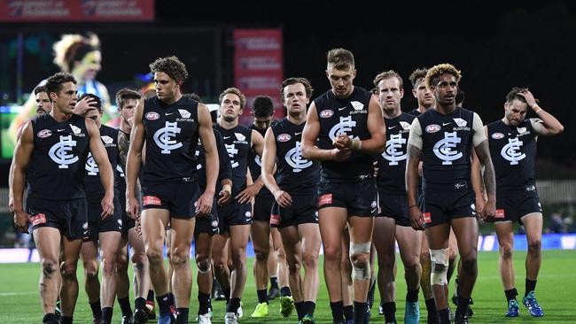 Carlton players leave the field after the horror loss to North Melbourne.