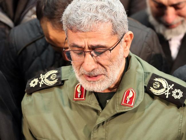 A handout picture provided by the office of Iran's supreme leader on January 6, 2020 shows the newly appointed commander of Iranian Revolutionary Guards Corps (IRGC), lieutenant general and commander of the Quds Force, Esmail Qaani (C), weeping over the coffin his predecessor Qasem Soleimani during their funeral ceremony in Tehran. The targeted killing of 62-year-old Soleimani ordered by US President Donald Trump saw Iran vow "severe revenge" before it also took a further step back from the already tattered 2015 nuclear accord with world powers. (Photo by HO / LEADER OFFICE / AFP) / / === RESTRICTED TO EDITORIAL USE - MANDATORY CREDIT "AFP PHOTO / HO / LEADER.IR" - NO MARKETING NO ADVERTISING CAMPAIGNS - DISTRIBUTED AS A SERVICE TO CLIENTS ===