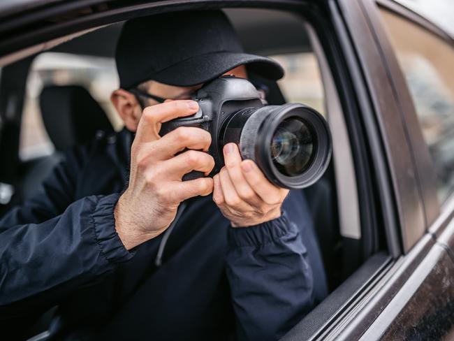 Paparazzi photographer is taking photos through car window. Private detective, undercover agent, plain-clothes police work, paparazzi concepts.