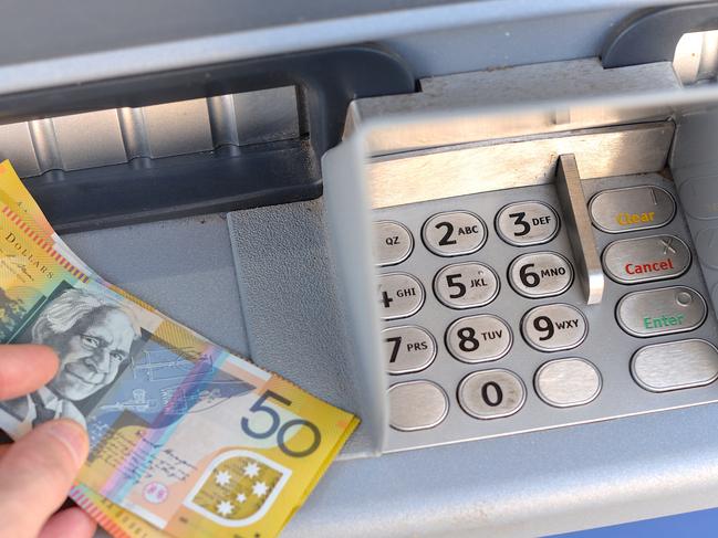 A man withdraws fifty dollar Australian notes from a bank ATM machine; Cash savings dollars money generic