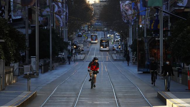 A bike rider in near-deserted Bourke St, Melbourne. Picture: Daniel Pockett