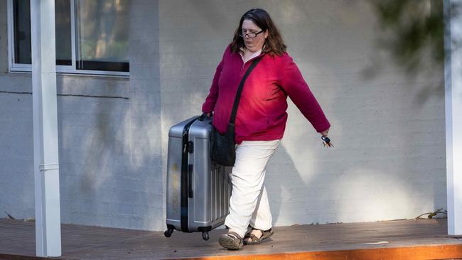 Ms Patterson leaving her home with a small suitcase. Picture: Jason Edwards