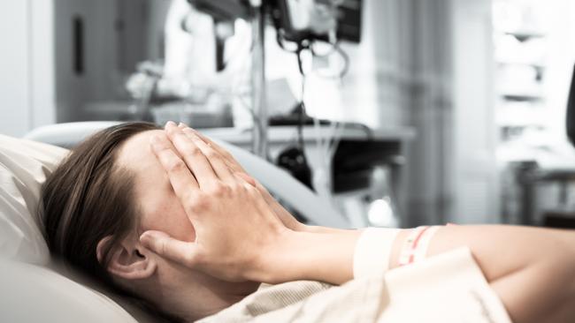 Young woman patient lying at hospital bed feeling sad and depressed worried. Disease feeling sick in health care and clinical attention concept.Picture: iStock