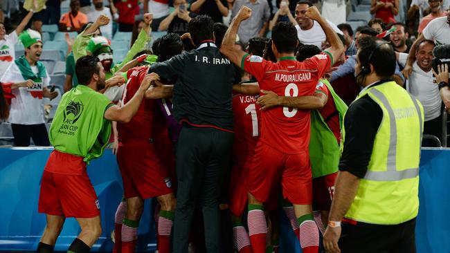 Iran celebrates scoring the opening goal with their fans against Qatar in their Group C football match in the AFC Asian Cup in Sydney on January 15, 2015. AFP PHOTO/Peter PARKS --IMAGE RESTRICTED TO EDITORIAL USE - STRICTLY NO COMMERCIAL USE