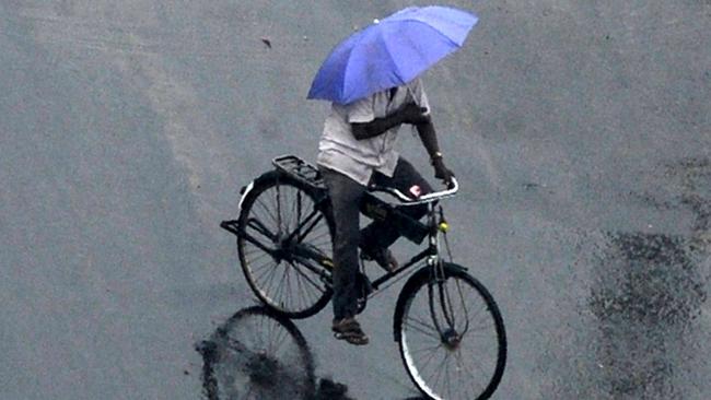 An Indian cyclist rides through heavy rains in Chennai on December 1, 2016. Tropical Cyclone 'Nada' was forecast to make landfall on the southern coast of India early December 1. Picture: Supplied.