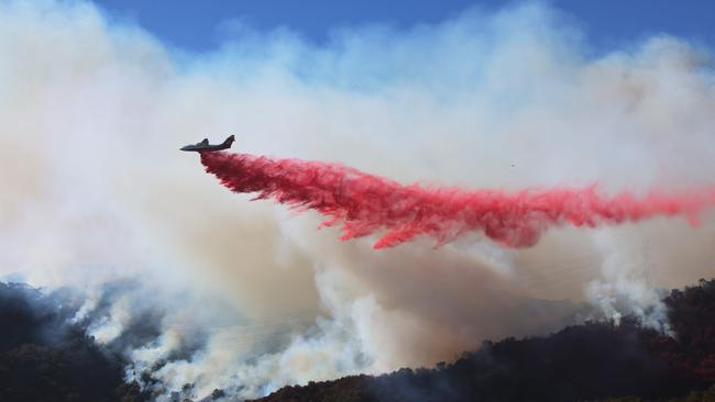 TOPSHOT - Retardant is dropped as the Palisades Fire grows near Encino Hills, California, on January 11, 2025. The Palisades Fire, the largest of the Los Angeles fires, spread toward previously untouched neighborhoods January 11, forcing new evacuations and dimming hopes that the disaster was coming under control. Across the city, at least 11 people have died as multiple fires have ripped through residential areas since January 7, razing thousands of homes in destruction that US President Joe Biden likened to a "war scene." News of the growing toll, announced late Thursday January 9 by the Los Angeles County Medical Examiner, came as swaths of the United States' second-largest city lay in ruins. (Photo by David Swanson / AFP)