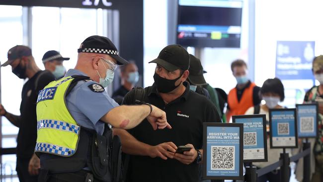 PERTH, AUSTRALIA - FEBRUARY 05: Arriving passengers scan the arrival registration QR codes at the Qantas Domestic terminal on February 05, 2022 in Perth, Australia. Western Australia is set to welcome some 10,000 arrivals over the weekend, local media reports said, as it eases its "hard border", which was among the strictest measures taken by any state, territory, or country in keeping potential Covid-19 infections at bay.  (Photo by Paul Kane/Getty Images)