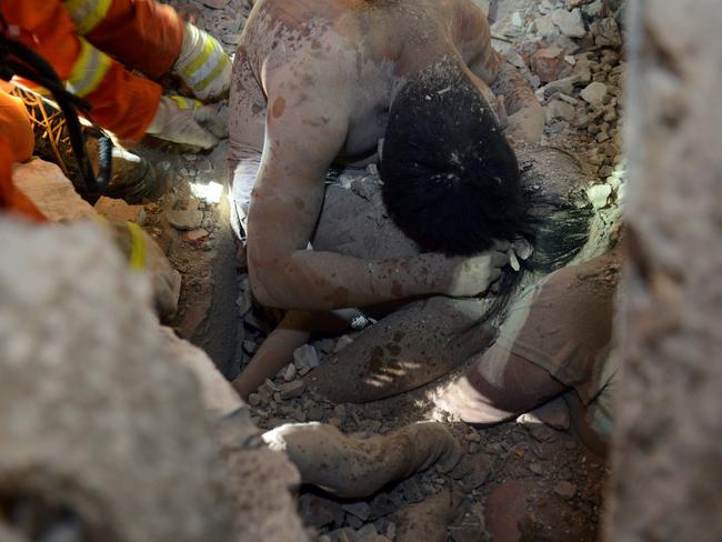 Rescuers trying to save three-year-old Wu Ningxi who was protected by her father’s embrace. Picture: AFP