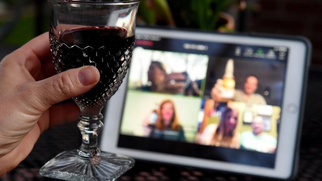 A woman lifts her glass and cheers with friends during a virtual happy hour amid the coronavirus crisis. Picture: AFP