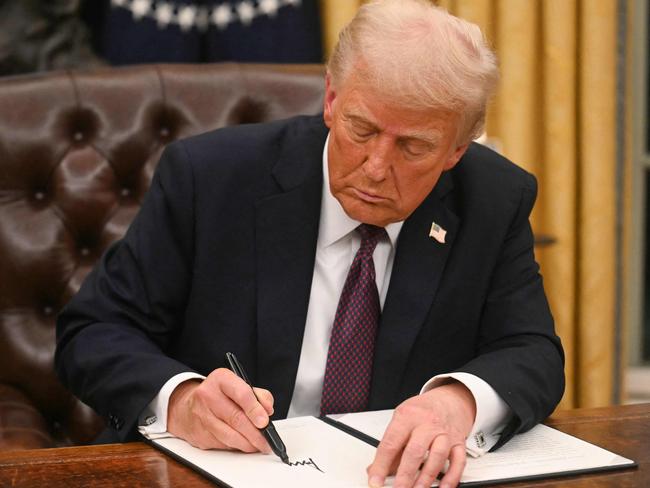 US President Donald Trump signs an executive order in the Oval Office of the WHite House in Washington, DC, on January 20, 2025. (Photo by Jim WATSON / POOL / AFP)