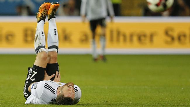 Germany's Shkodran Mustafi holds his leg. (AP Photo/Michael Probst)