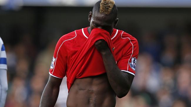 Liverpool's Italian striker Mario Balotelli reacts during the English Premier League football match between Queens Park Rangers and Liverpool at Loftus Road in London on October 19, 2014. AFP PHOTO / ADRIAN DENNIS RESTRICTED TO EDITORIAL USE. No use with unauthorized audio, video, data, fixture lists, club/league logos or “live” services. Online in-match use limited to 45 images, no video emulation. No use in betting, games or single club/league/player publications.