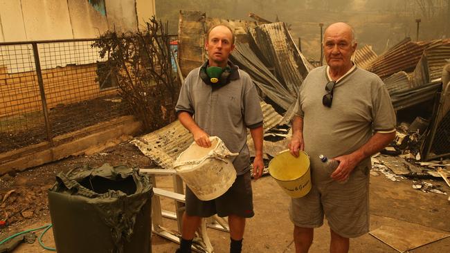 Jamie Gould and Frank Thatcher worked together to save several houses using buckets. Picture: Rohan Kelly